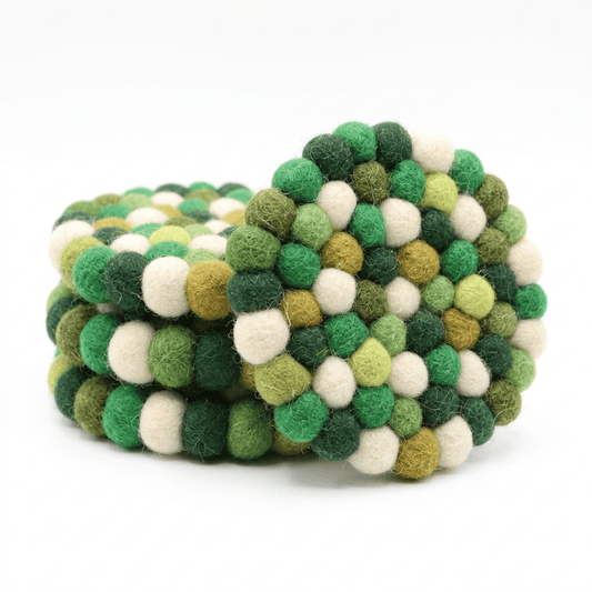 Round wool felt coaster with green, cream, and golden pom-pom ball pattern