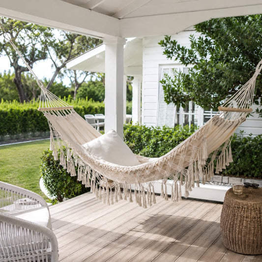 Cream macrame hammock with long tassel fringe and woven net seat