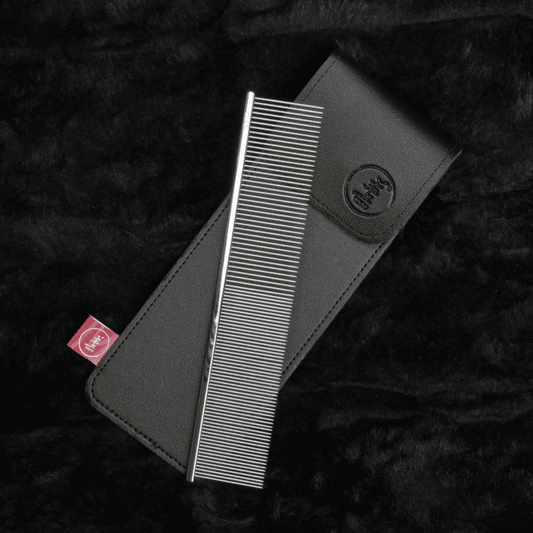 Twin-pin hair comb in a dark leather-style cover, metal teeth visible