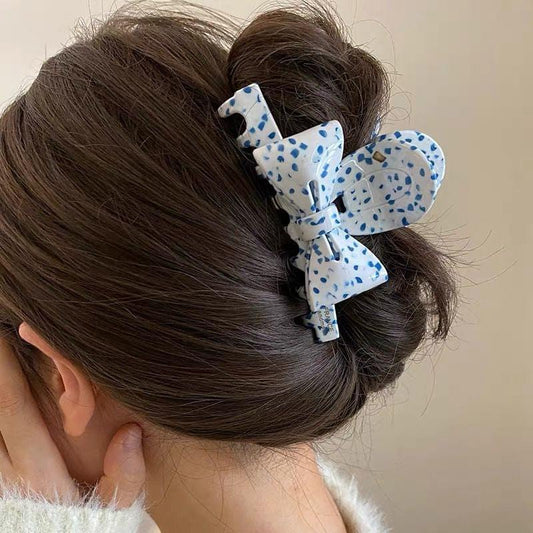 Blue polka dot bow hair claw on hair bun, medium French ribbon style