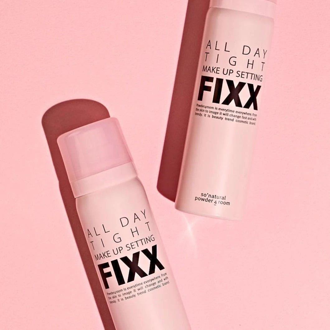 Makeup setting spray bottles, pink canisters with caps, angled close-up