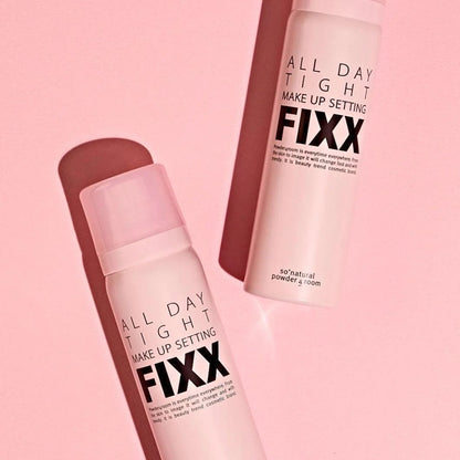 Makeup setting spray bottles, pink canisters with caps, angled close-up