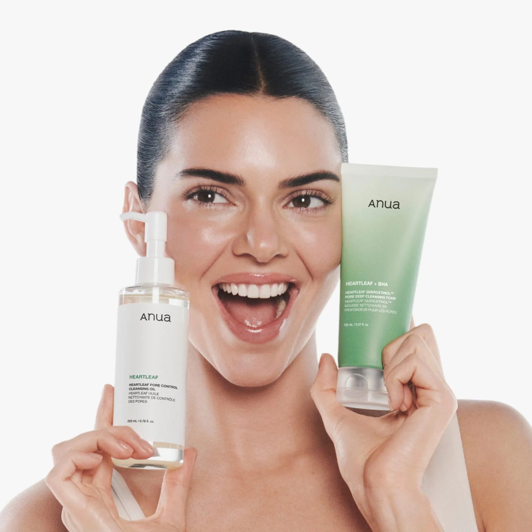 ANUA cleansing duo: Heartleaf oil bottle and green foam tube held by smiling woman