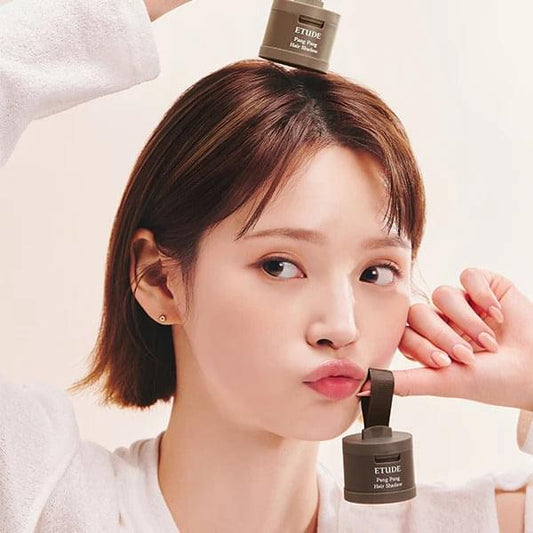 Hair shadow compact held near hairline on model