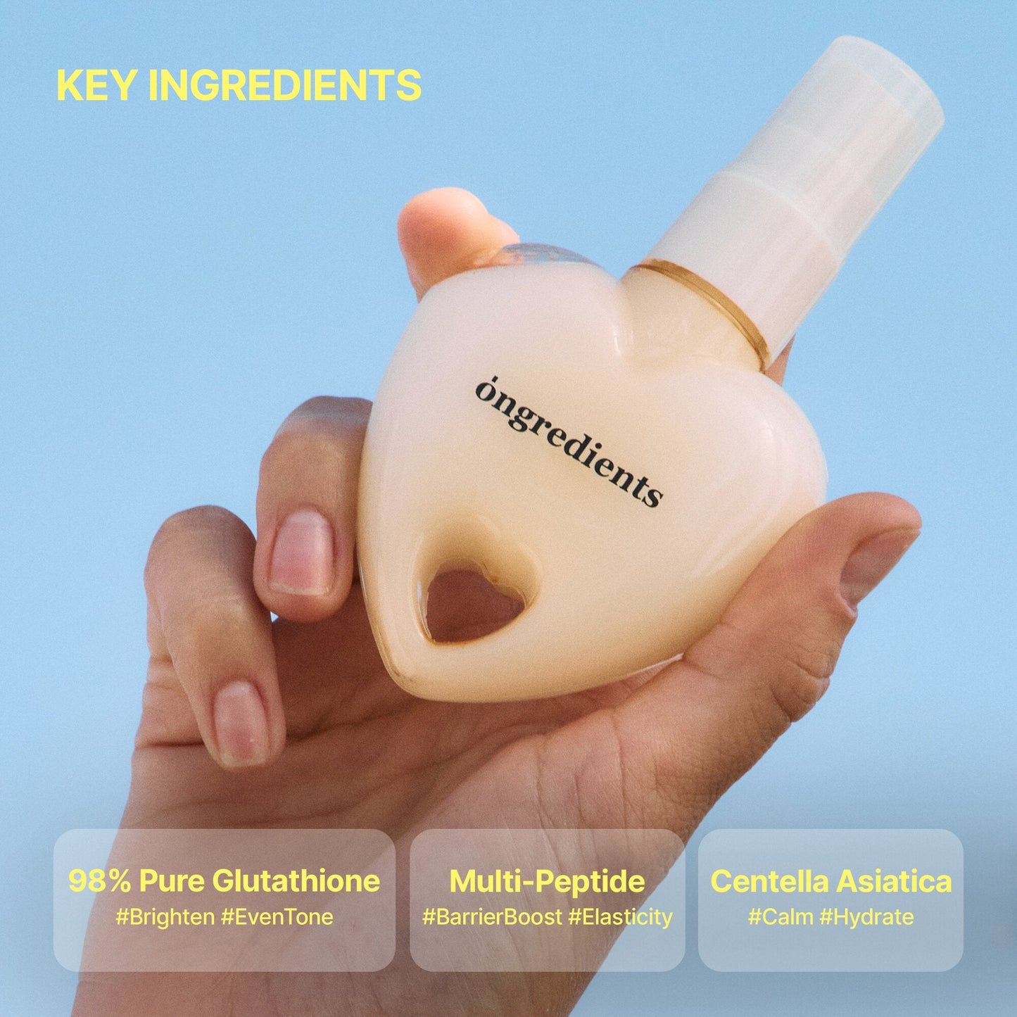 Hands holding a heart-shaped glow mist bottle with white spray nozzle and ongredients logo