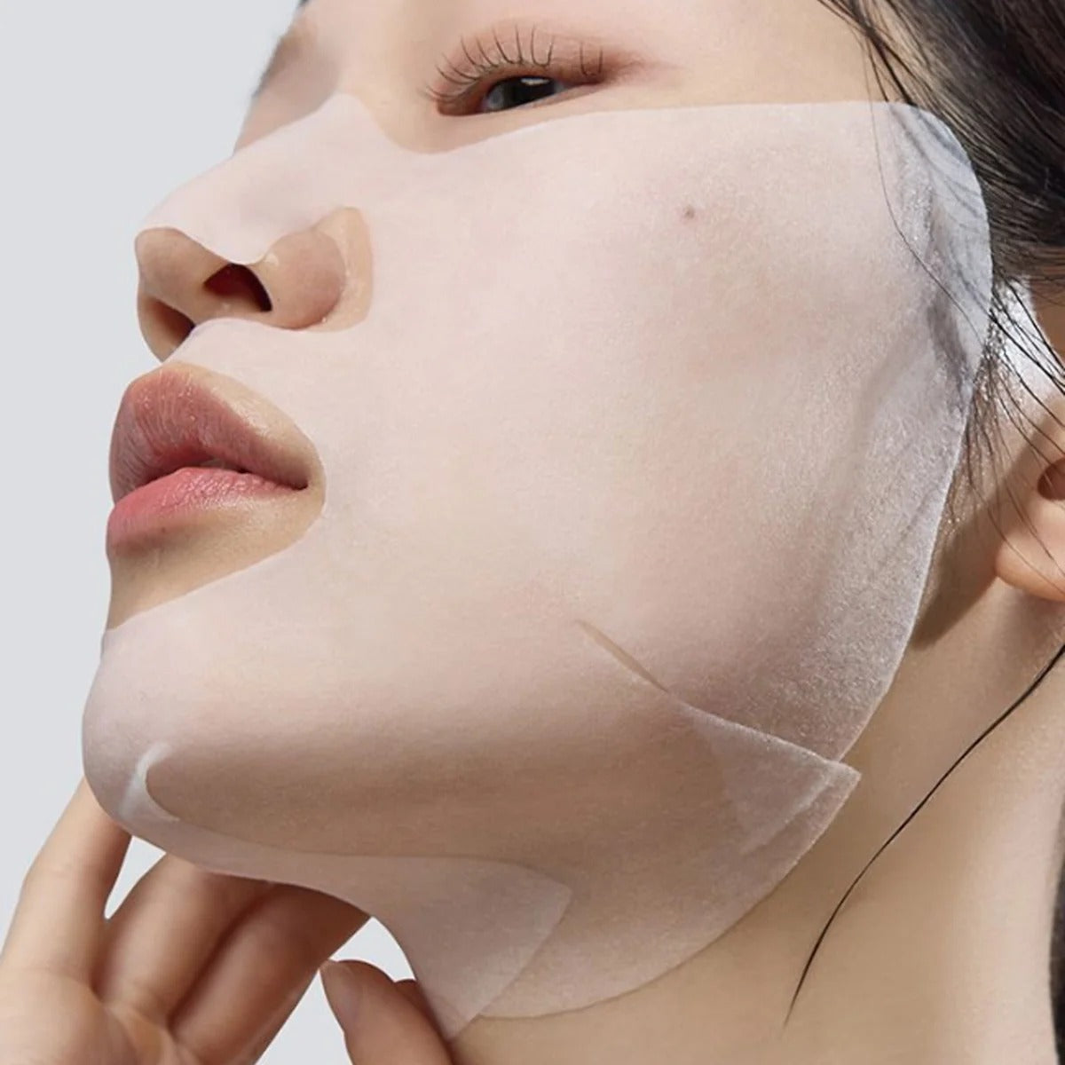 Slim facial sheet mask on face, covering forehead, nose, and cheeks