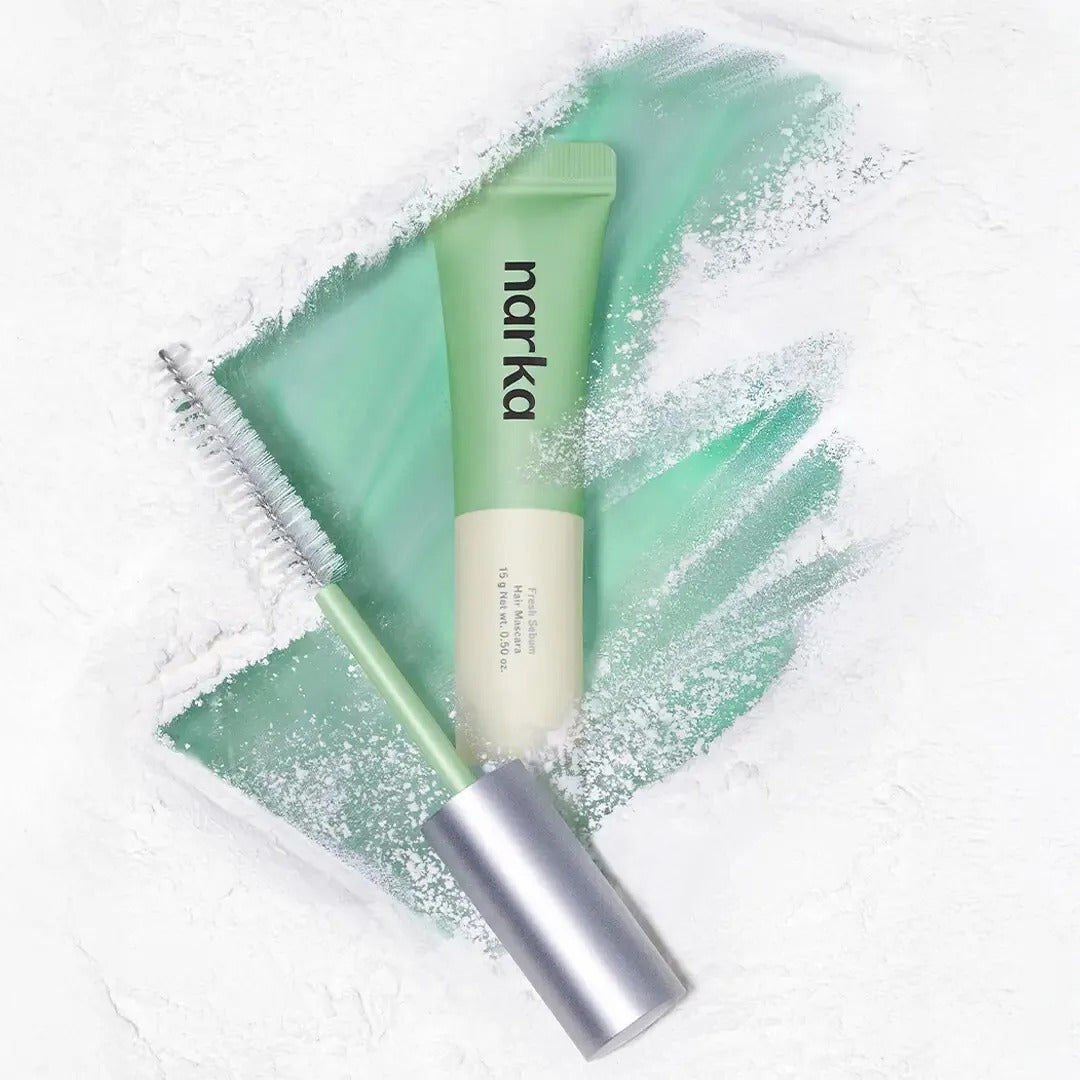 Hair sebum hair mascara with mint tube and brush, shown on light green gel
