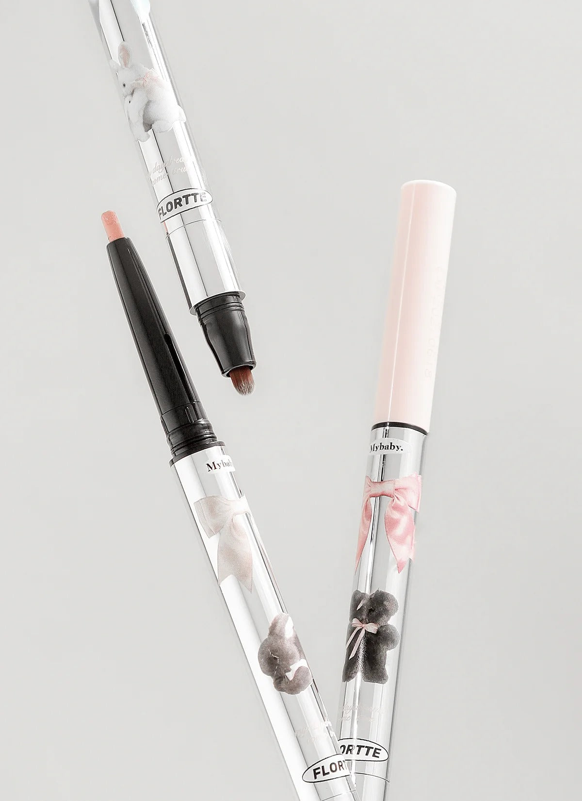Two retractable double-ended eye pencils with cream and dark tips in close-up