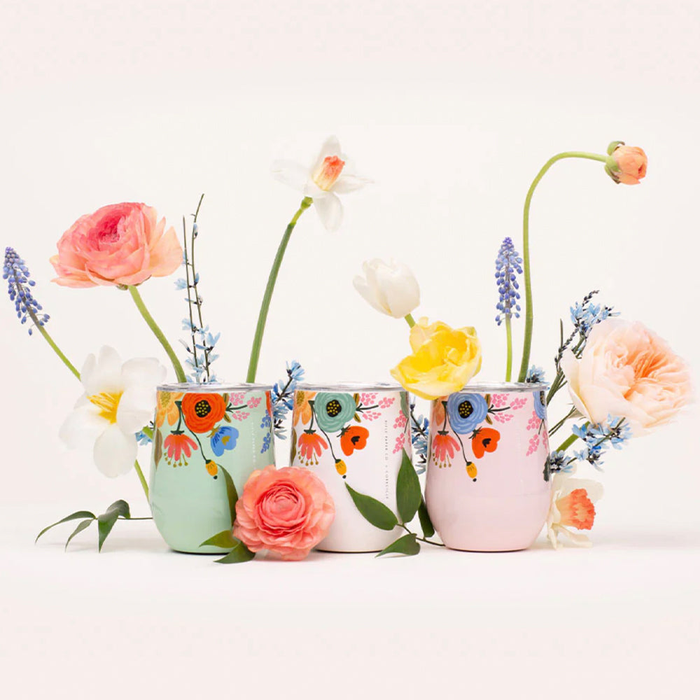 Three cream stemless tumblers with colorful floral pattern and flower accents