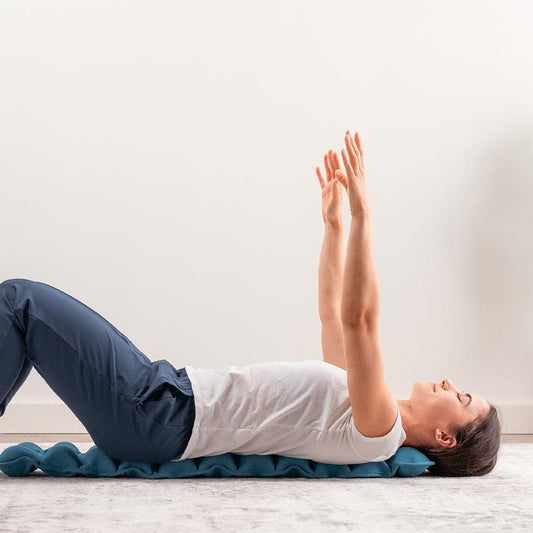 Blue spine stretcher cushion under back for supported stretching