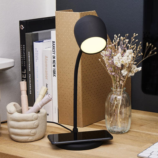 Black desk lamp with base featuring wireless charging surface