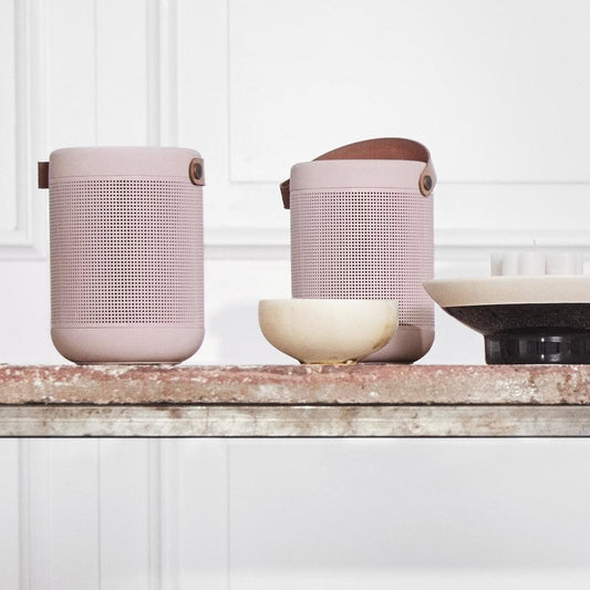Dusty rose portable Bluetooth speaker with carry strap, perforated grille and top control