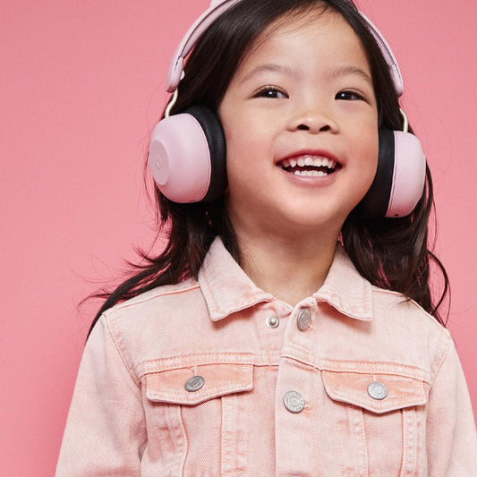 Kids Bluetooth headphones in dusty rose and black, worn over child’s ears