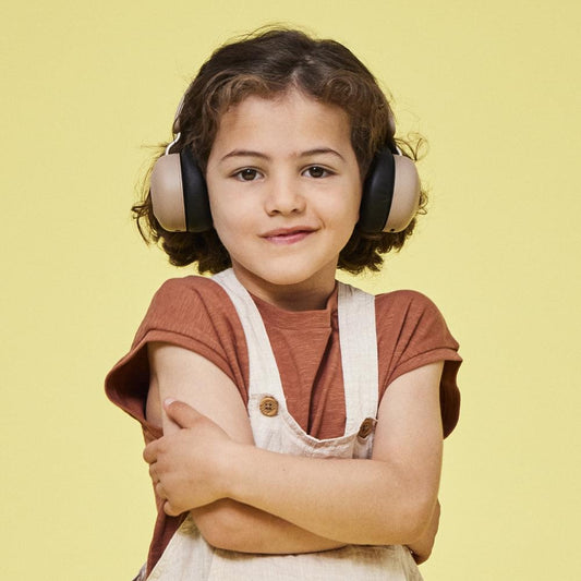 Child wearing kids Bluetooth headphones in ivory with black ear cushions