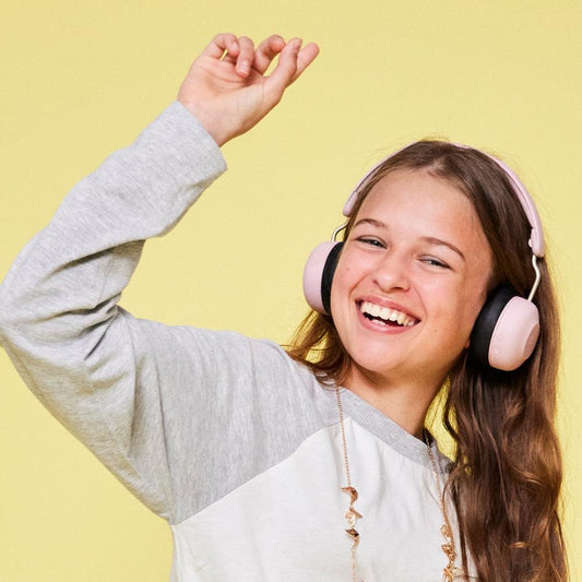 Kids Bluetooth over-ear headphones in dusty rose worn by smiling child