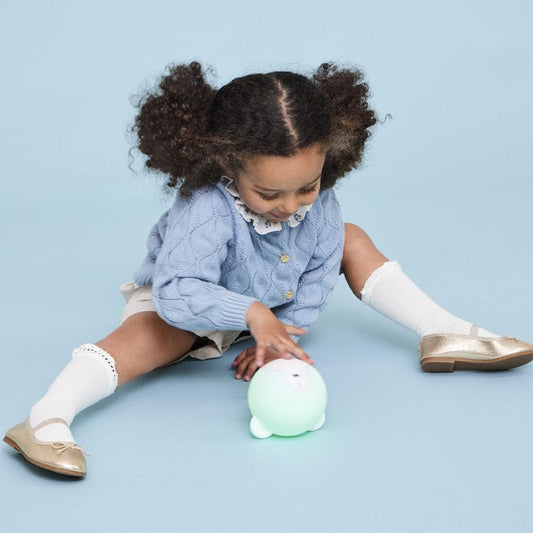 White bear blob kids lamp glowing while a child plays with it