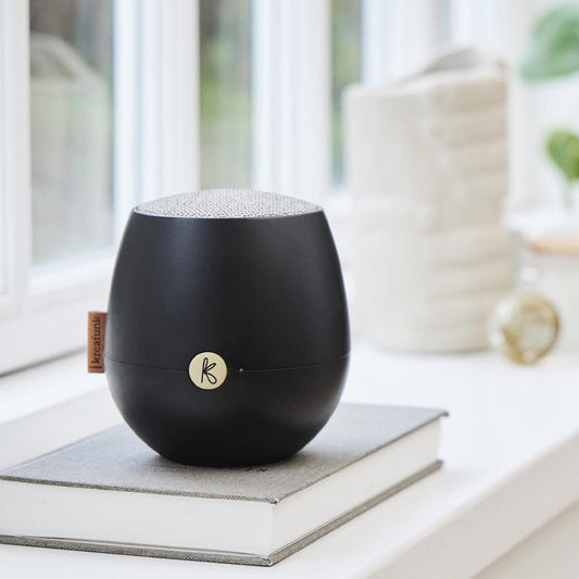 Black Bluetooth speaker with circular logo on front and speaker top grille