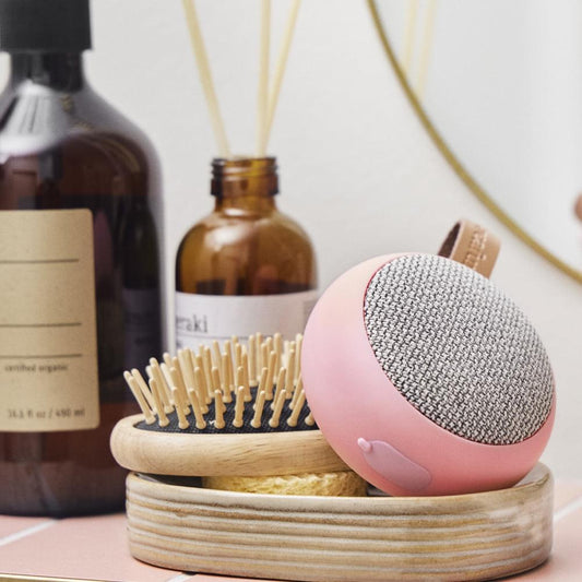 Pink portable Bluetooth speaker with round gray fabric speaker grille