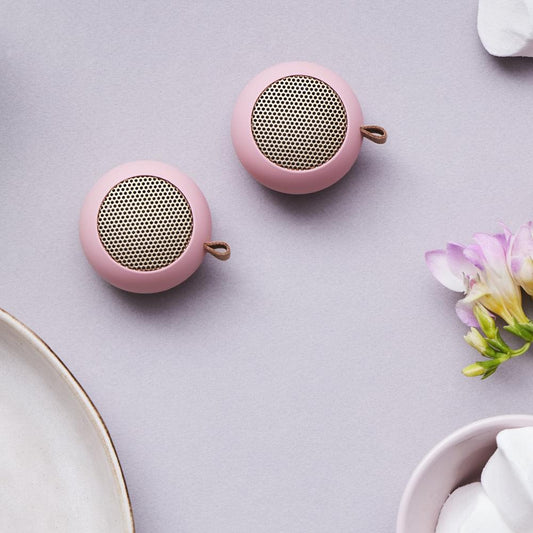 Pink mini Bluetooth speaker with circular grille and leather loop handle