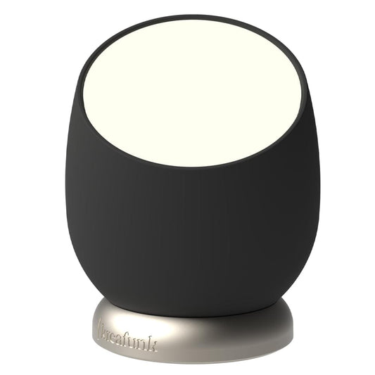 Black rechargeable table lamp with glowing circular top and round metal base