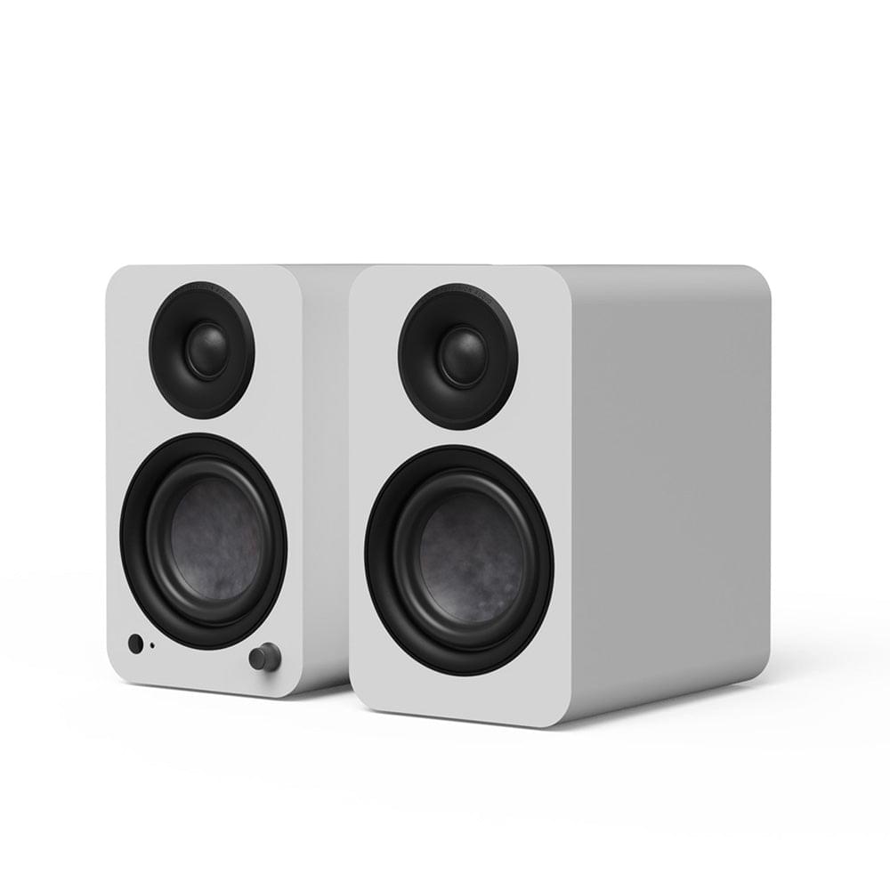 Matte white powered bookshelf speakers, side-by-side front view with black tweeters and woofers.