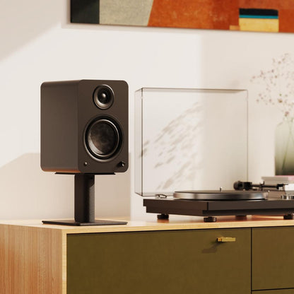 Matte black powered bookshelf speaker with tweeter and woofer, angled front view