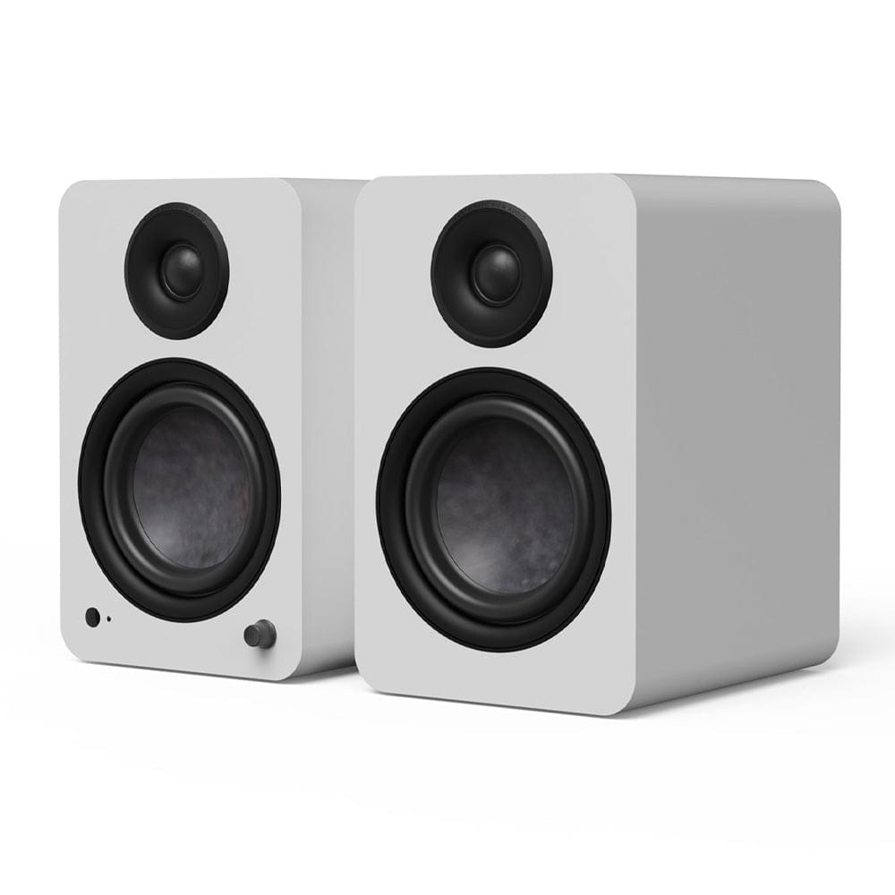 Matte white powered bookshelf speakers, black drivers and side profile, angled view pair