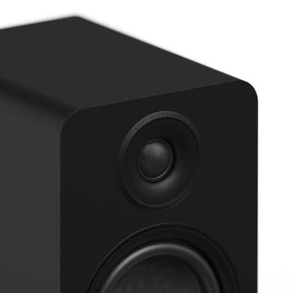 Matte black Kanto YU6 passive bookshelf speaker, close-up of tweeter and woofer