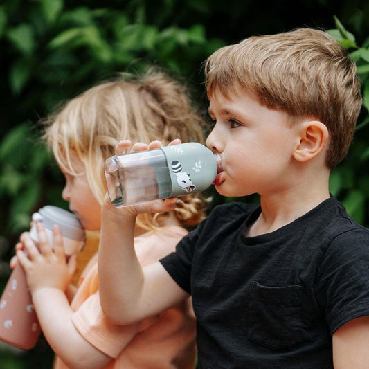 Mint green reusable water bottle with raccoon graphic, child drinking