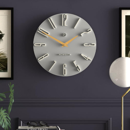 Grey wall clock with metal hour markers, gold hands, and Newgate dial logo