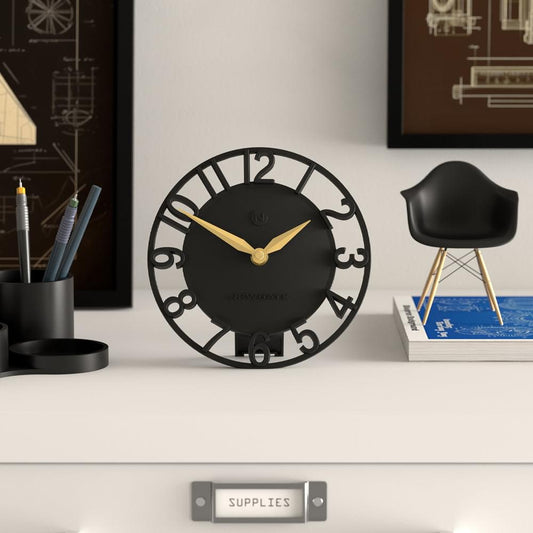 Black mantel clock with open ring design, gold hands, and Roman-style numbers