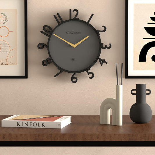 Newgate Monorail wall clock on wall, dark dial with black frame and gold hands