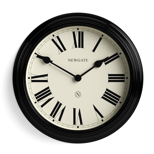Black Newgate wall clock close-up with cream face, Roman numerals, and minute markers