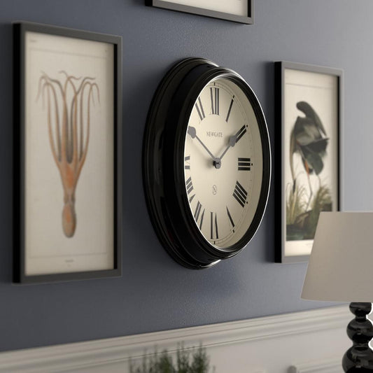Black Newgate wall clock side view with oval frame and cream dial