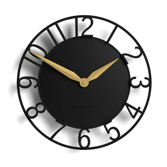 Black wall clock with gold hands, Roman-style numerals, and decorative dial symbols.