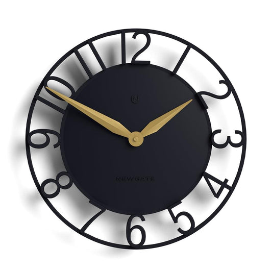 Round wall clock close-up: dark dial, gold minute and hour hands, black numeral markers