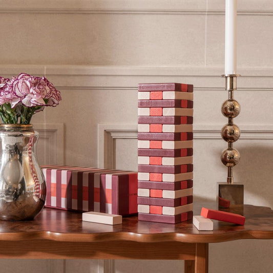 Tumbling tower wooden block stack in red and cream with a few loose pieces