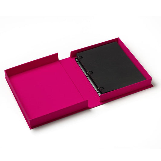 Magenta Printworks photo album open, showing black photo pages with ring-style binding