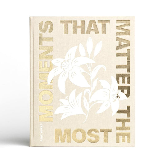 Beige hardcover photo album with gold “THAT MATTERS” and white floral title design.