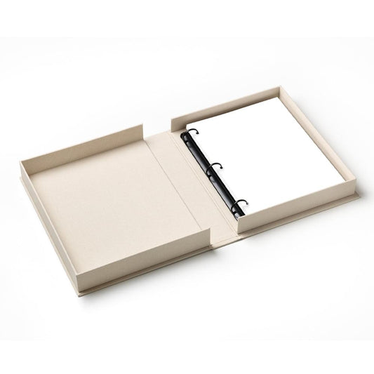 Beige photo album open with blank pages and black ring binder inside.