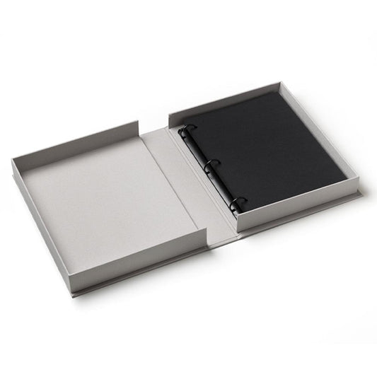Opened grey photo album with black page inserts and black elastic strap