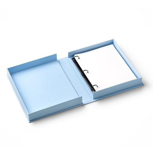 Blue embroidered photo album with black spiral rings, open layout