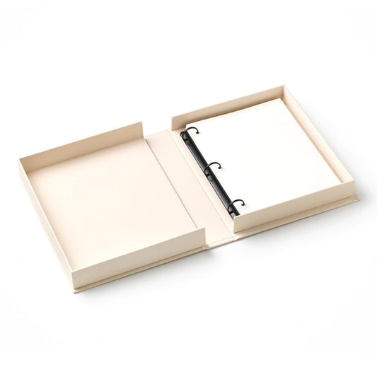 Embroidered photo album open flat with beige pages and black ring-bound strap