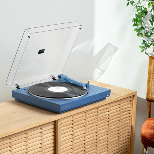 Victrola blue automatic turntable on a wooden cabinet with open dust cover and black record