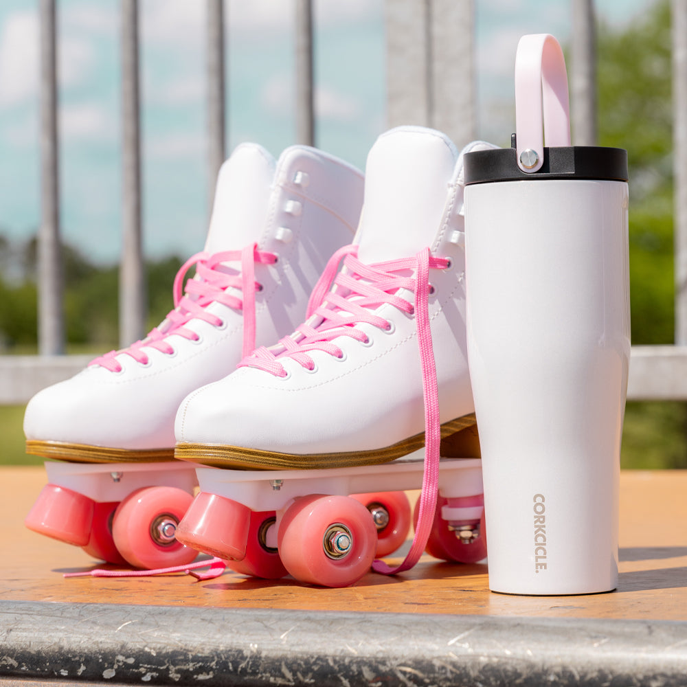 Corkcicle Go Cup XL gloss white insulated travel cup with black lid on skateboard deck
