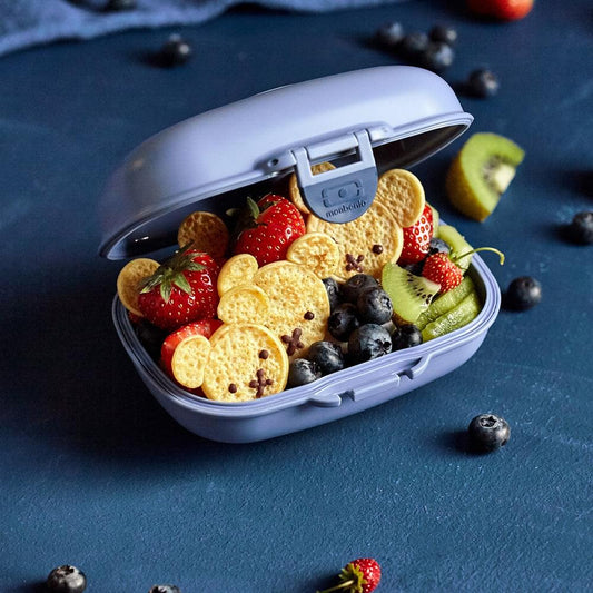 Open blue kids snack box showing inner compartment with strawberries, blueberries, and slices