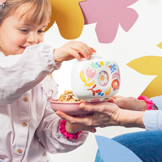 Kids snack box held by a child, Paper Cut print on white lid with pink base