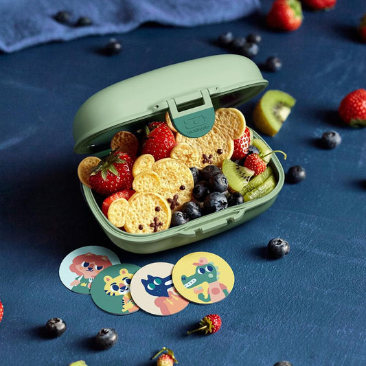 Kids snack box with open lid, filled with strawberries, blueberries, and snack pieces