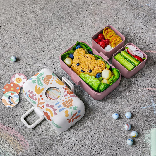 Kids bento box open with three compartments and colorful food, floral lid design