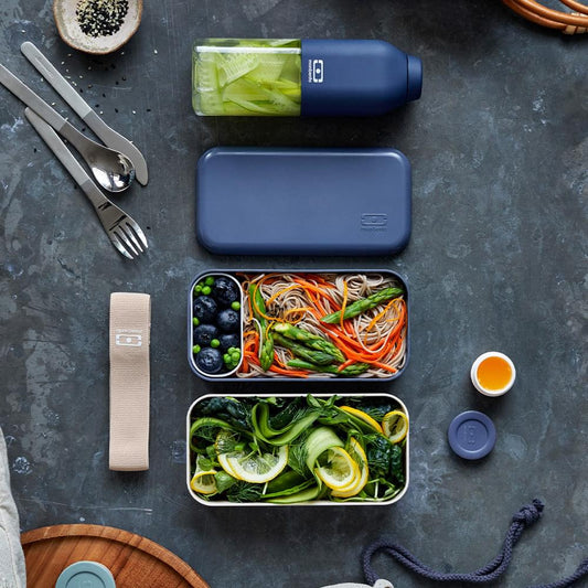 Blue and beige bento lunch box with open lid and two stacked food compartments